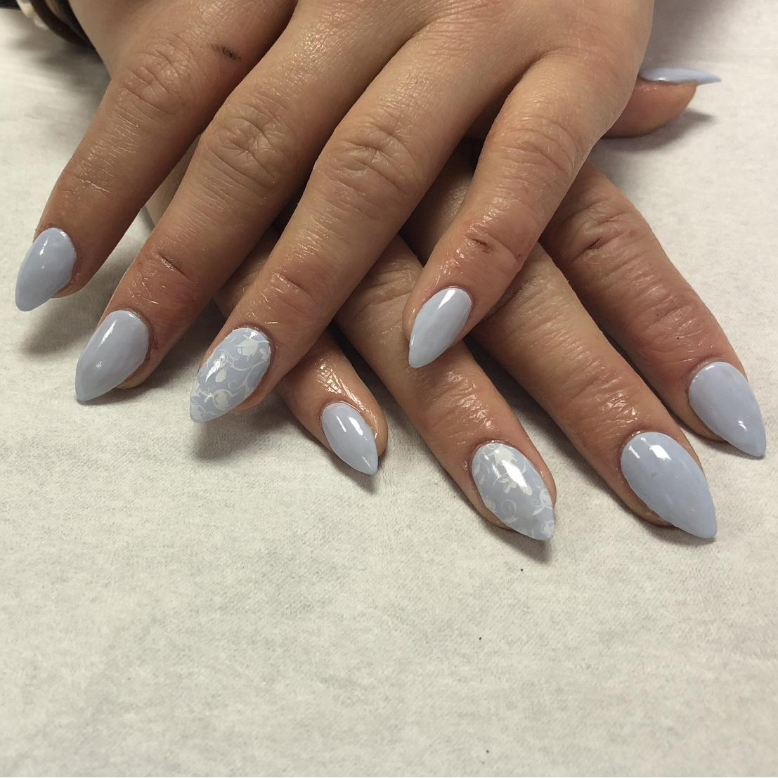 Pale blue nails with delicate white floral details