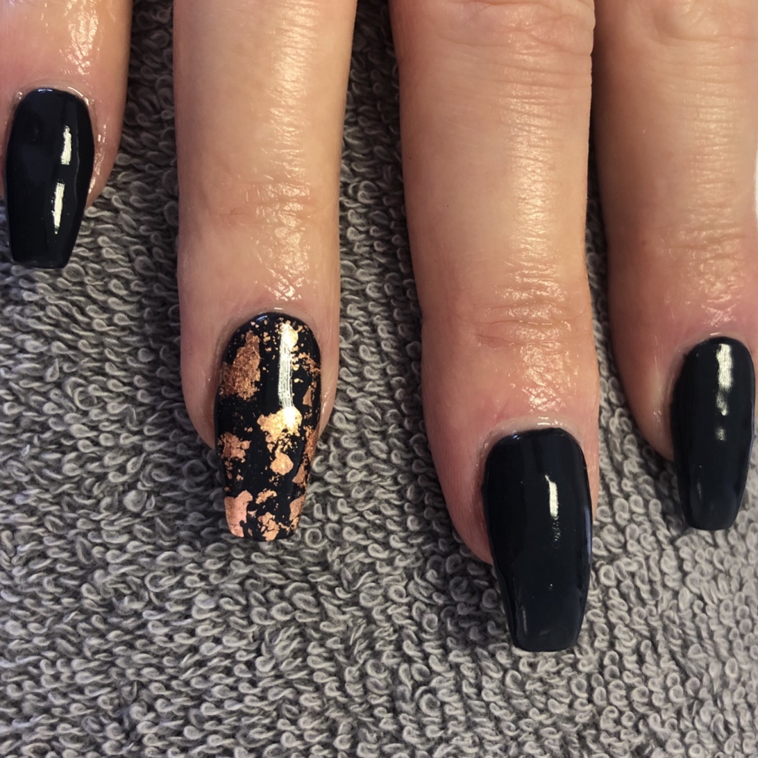 Glossy black nails with gold foil accents, created at Elegance